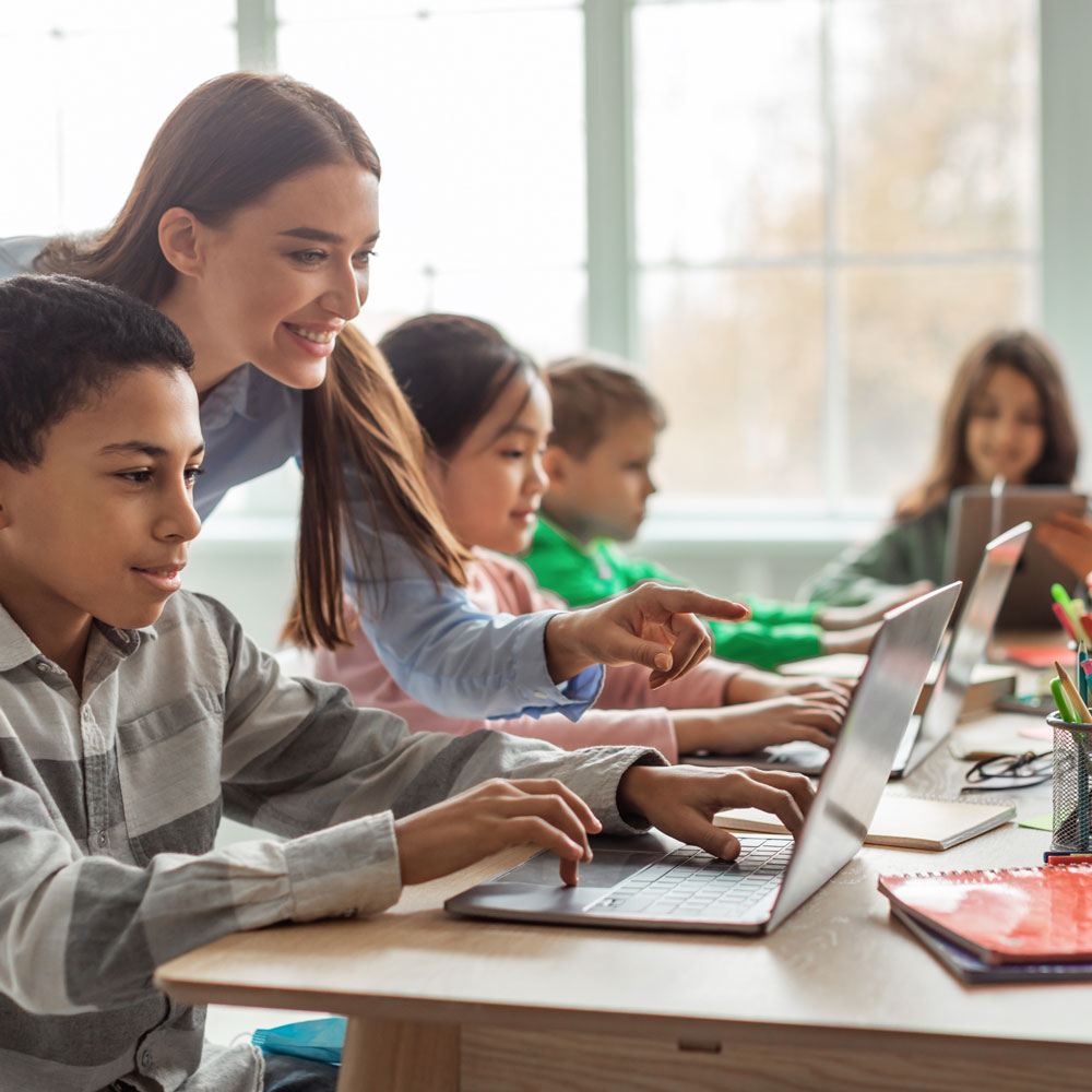 Teacher helping student with technology