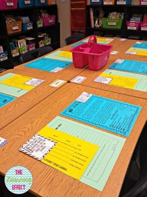 Student desks set up for back to school night with paperwork on top